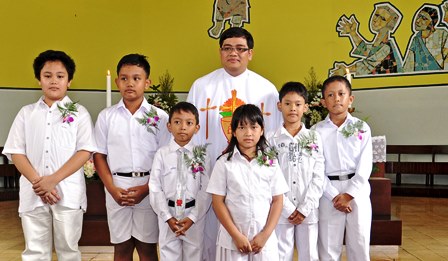 Children in Indonesia gather together after their First Communion in the Catholic Church.