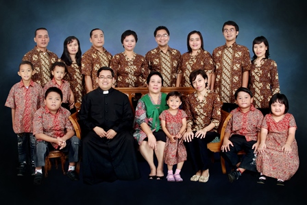A Missionary of the Holy Family priest meets with his family in Indonesia with all wearing traditional outfits.