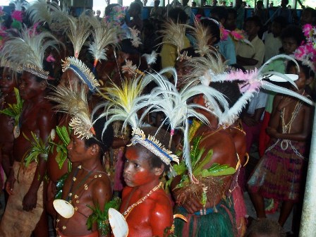 Children in a primitive area of Papua New Guinea dress in their cultural attire at a First Communion celebration.