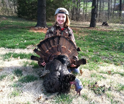 This is a photograph of Miss Brianna, a nine year old Turkey Hunter, with her first turkey.